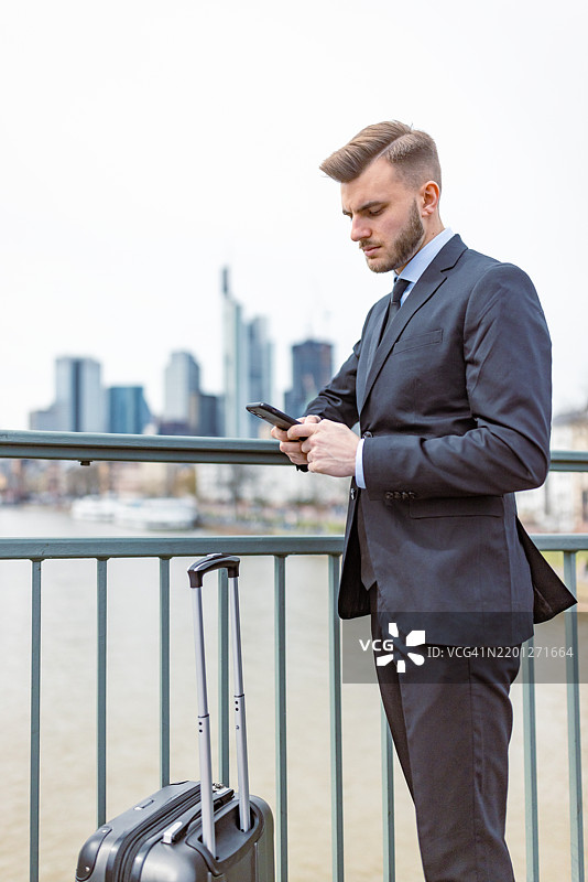 商人在早晨的城市桥上查看手机图片素材