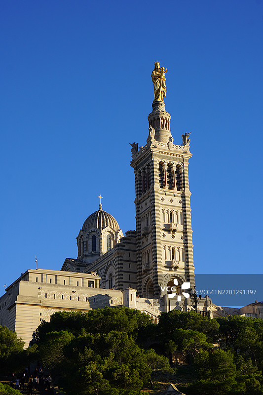法国马赛的圣母院高耸于树木之上图片素材