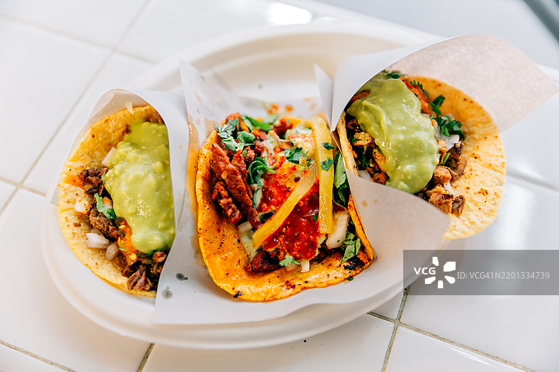 牛肉、鸡肉和阿尔帕斯托塔可配鳄梨酱特写图片素材