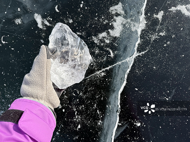 女人的手在贝加尔湖上握着一块冰块图片素材
