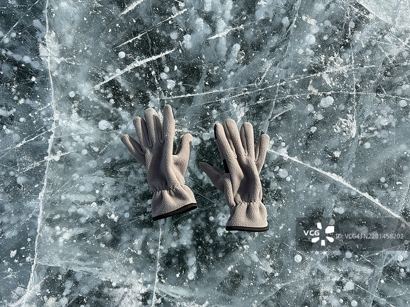 冬季冰封的贝加尔湖上，温暖的手套放在起泡的冰面上图片素材