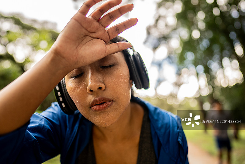 疲惫的年轻女性在公共公园里跑步图片素材