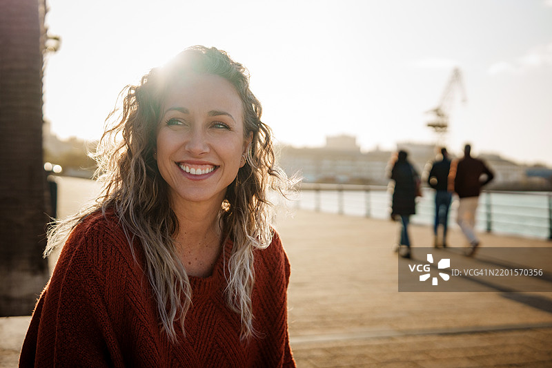 微笑的女性在城市码头享受阳光图片素材