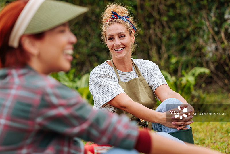 女性在郁郁葱葱的绿地中享受园艺乐趣图片素材