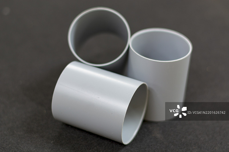 管道堆叠在一起，代表工业原材料商品行业和商业。图片素材