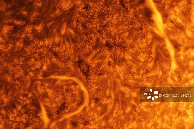 我们的太阳在H-alpha光下。太阳表面发出H-alpha光，显示出旋转的等离子体和细丝。图片素材
