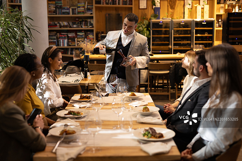 多种族的人们在豪华餐厅品尝葡萄酒图片素材