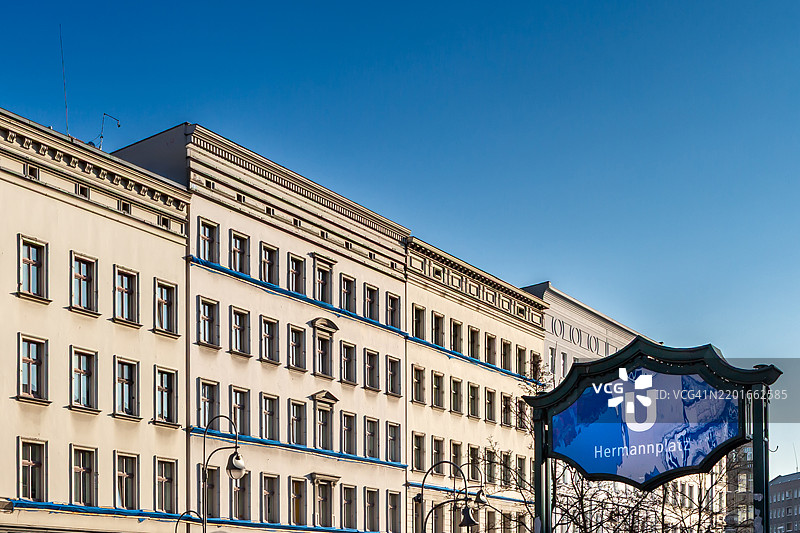 地铁标志“赫尔曼广场”，背景是德国首都柏林的住宅建筑外立面图片素材