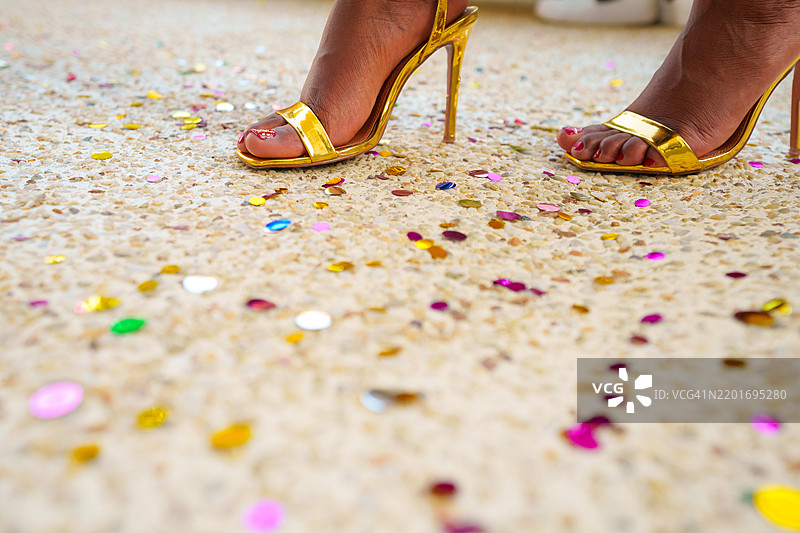 派对上的五彩纸屑和时尚庆祝：穿高跟鞋的女性腿部特写图片素材