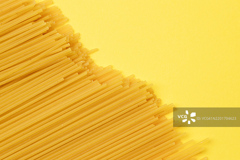 一堆凌乱的生意大利面在黄色背景上图片素材