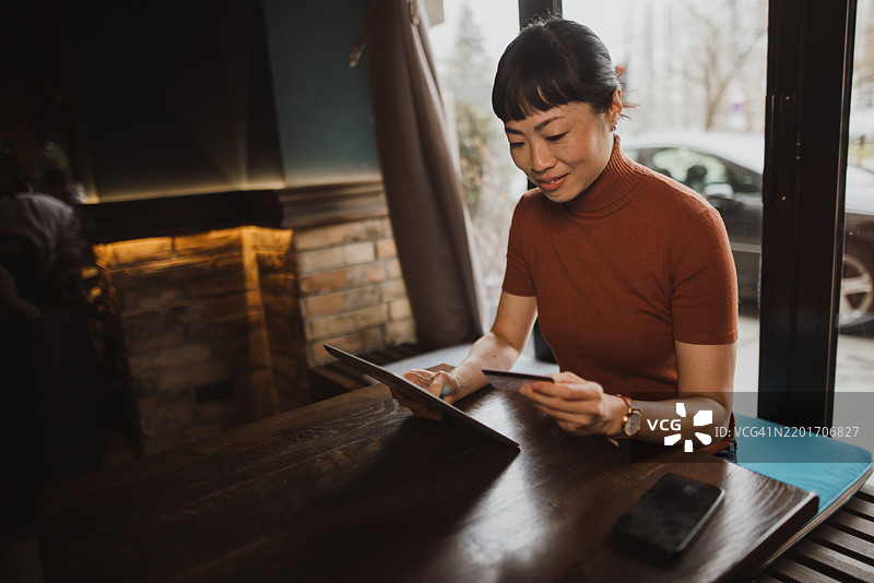 快乐的女性在网上支付商品费用图片素材