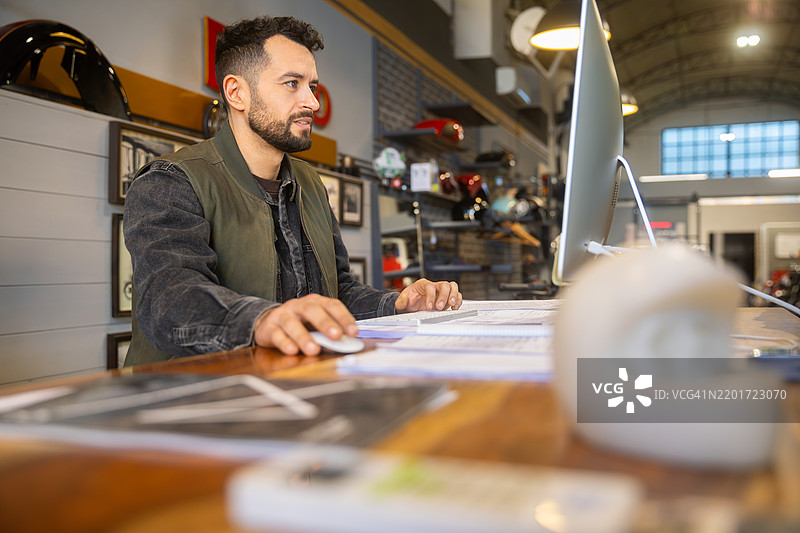 摩托车店员工在电脑前工作图片素材