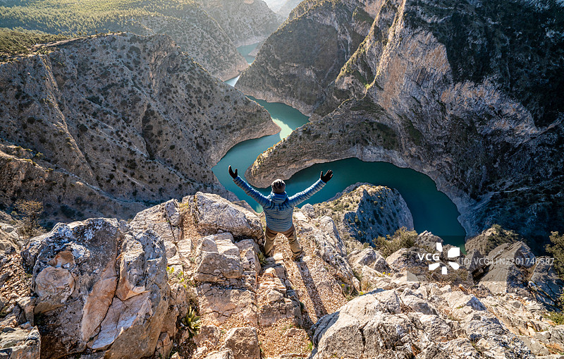 登山者在欣赏美丽的阿拉帕皮斯蒂峡谷时举起双臂，位于艾登，德尼兹利。图片素材