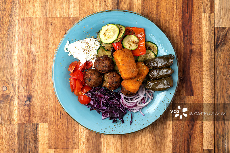 慢炖撕扯猪肉，蒜泥蛋黄酱，甜土豆和用有机橄榄油烤制的蔬菜，腌制红卷心菜，洋葱和樱桃番茄图片素材