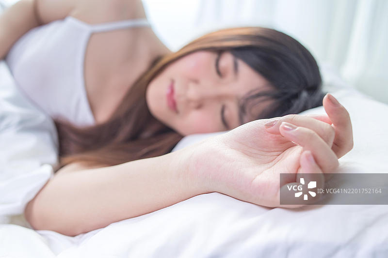 一位穿着白色衣服的亚洲女性在睡觉图片素材