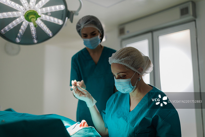 鼻部手术进行中，护士协助外科医生图片素材