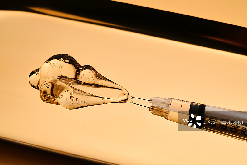 一滴凝胶从注射器中流出，用于美容程序图片素材