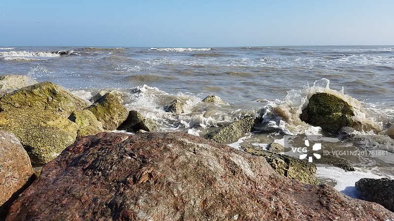 德克萨斯州加尔维斯顿的岩石海滩上波浪拍打的场景图片素材