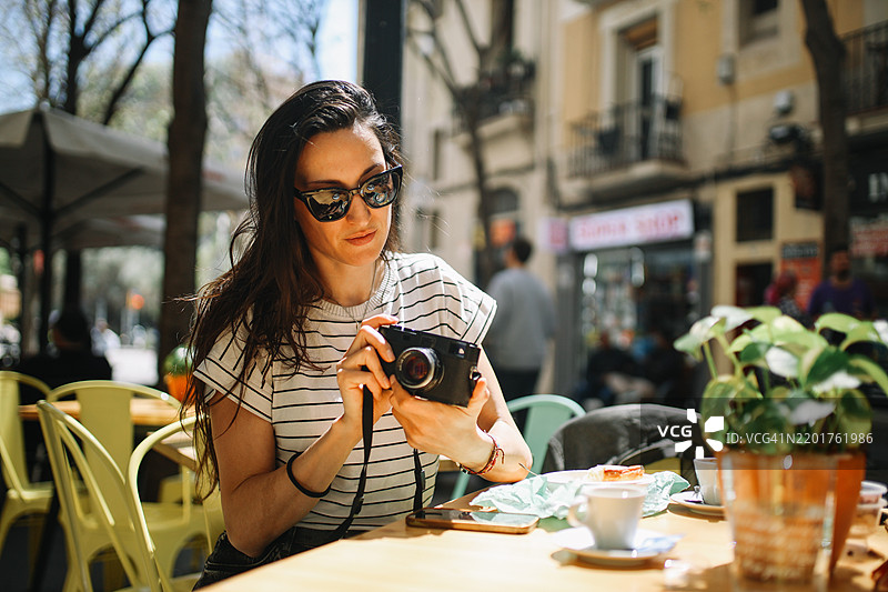 在巴塞罗那咖啡馆里的胶卷摄影师图片素材