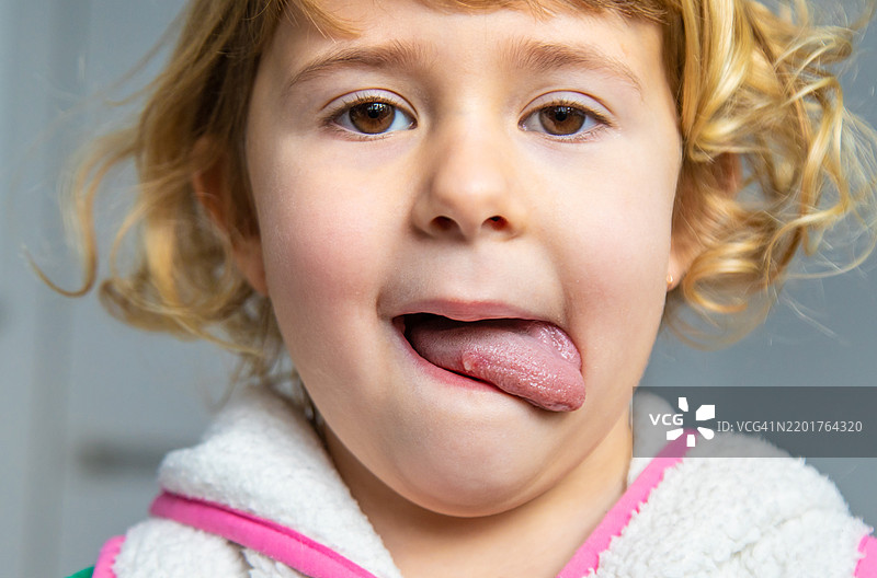 孩子咬到了伤口的舌头，选择性聚焦图片素材