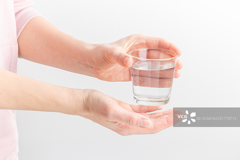 女性手中握着一杯清澈的水，健康饮品，水的平衡，环境保护与医疗保健的概念，世界水日，芬兰图片素材