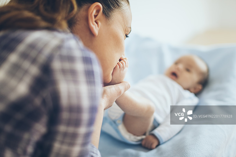 母亲与婴儿在柔软的毯子上亲密互动图片素材
