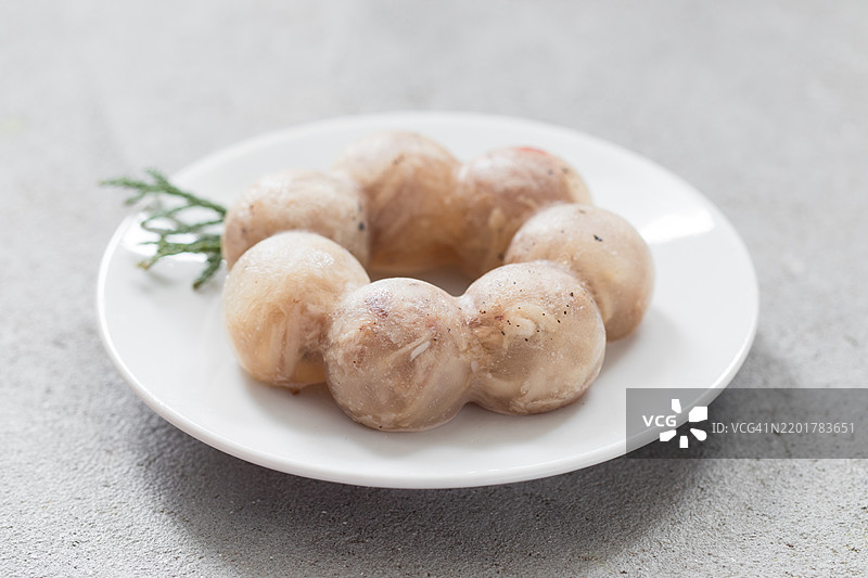 明胶鸡肉。盘子里的肉冻。浅灰色背景。特写。图片素材