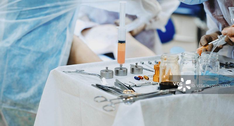 医疗专业人员在医院的无菌环境中使用注射器和工具进行手术图片素材