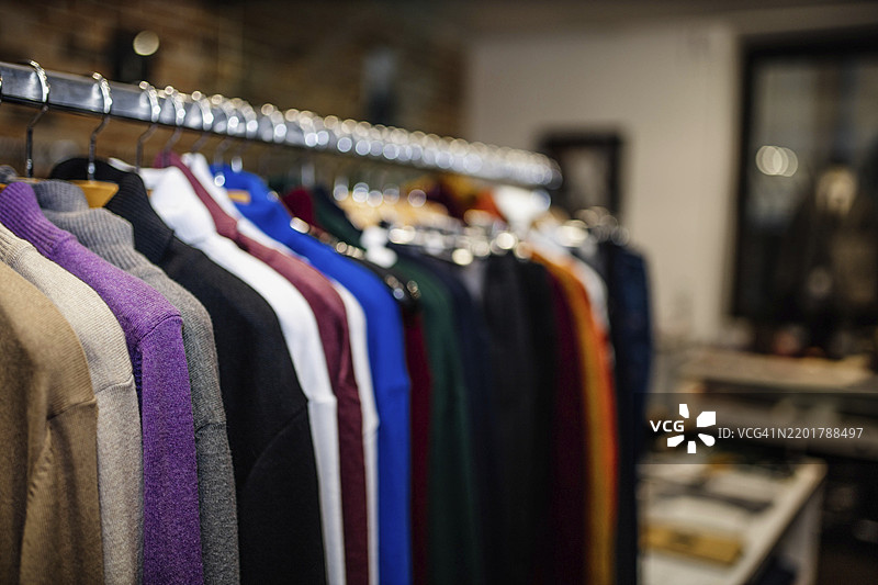 商店里展示的各种颜色的毛衣挂在衣架上图片素材