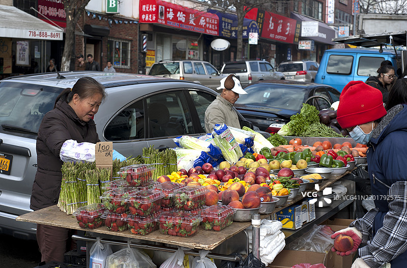 华裔美国水果商在纽约市法拉盛的户外市场出售他们的农产品。图片素材