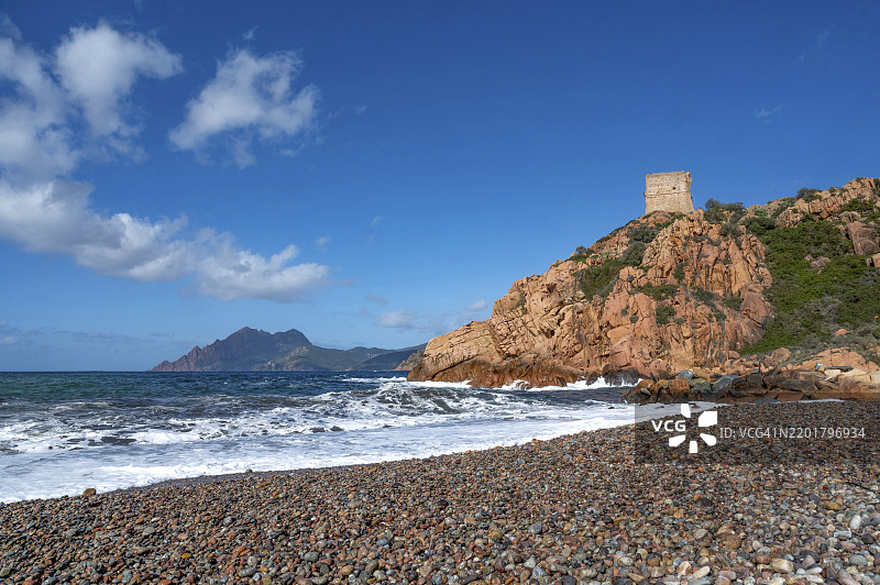 从海滩俯瞰红色岩石和由天然石材建成的热那亚塔（Tour Génoise de Porto），位于波尔图河口附近的波尔图-马里纳，坐落在世界遗产波尔图湾，科西嘉岛西海岸的波尔图、奥塔。图片素材