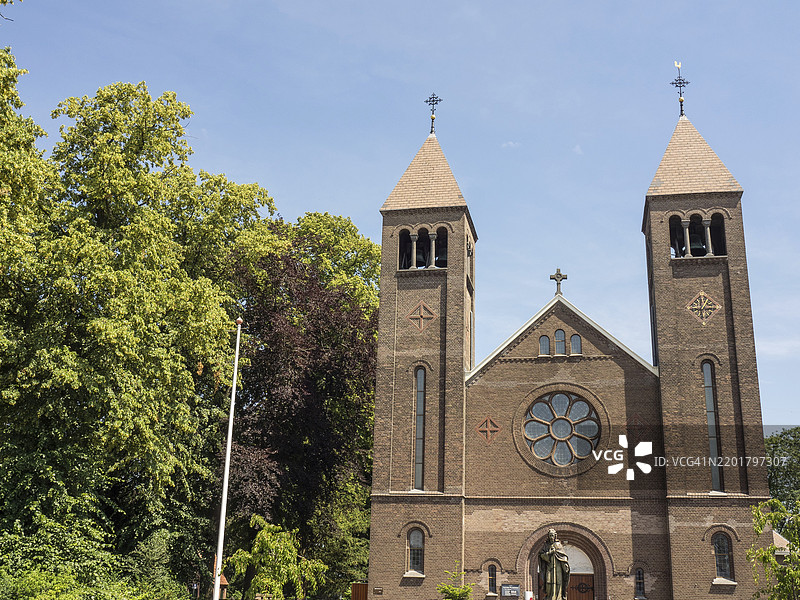 荷兰赫尔德兰省乌尔夫特的教堂，拥有两个钟楼和圆形窗户，阳光明媚。图片素材