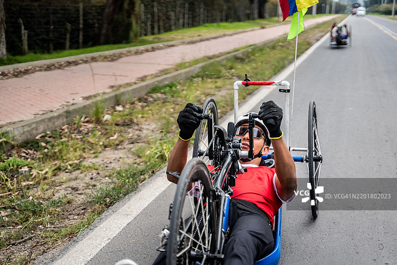 残疾运动员在城市街道上骑行手动自行车图片素材