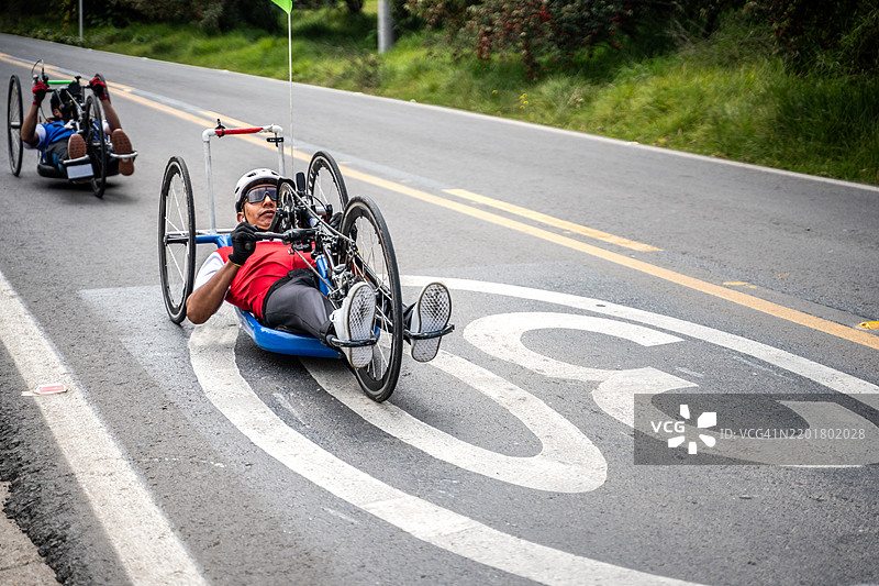 残疾运动员在城市街道上骑行手动自行车图片素材