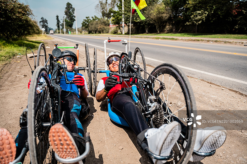 残疾运动员在城市街道上骑着手动自行车交谈图片素材