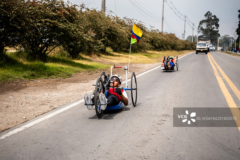残疾运动员在城市街道上骑行手动自行车图片素材