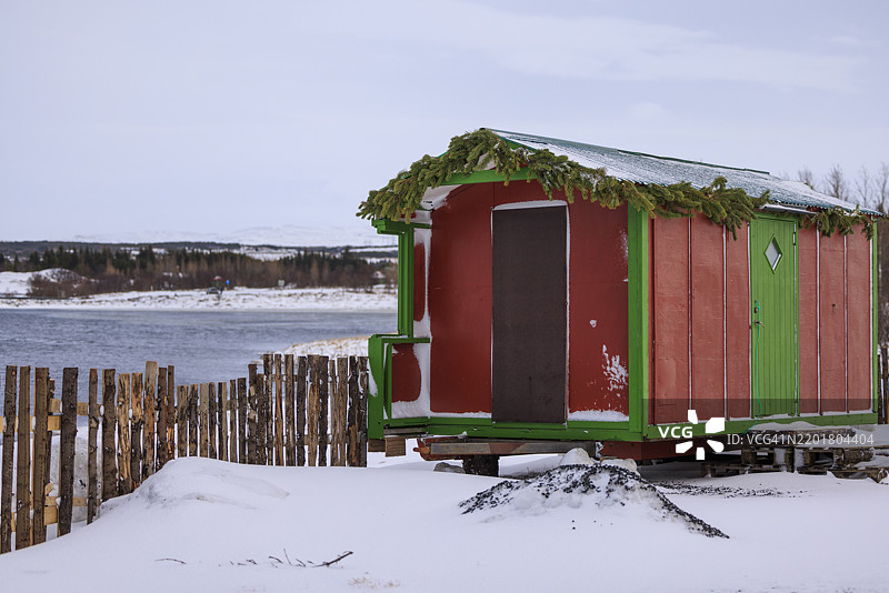 雷克雅未克冰冻景观中的迷人季节小屋图片素材