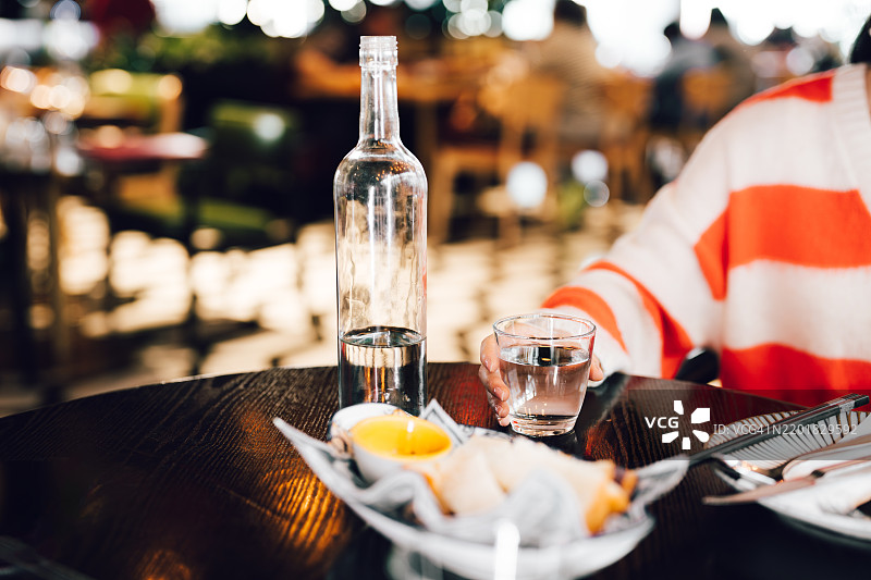 亚洲女性在餐厅用午餐时喝水的特写。健康生活方式，保持水分。图片素材