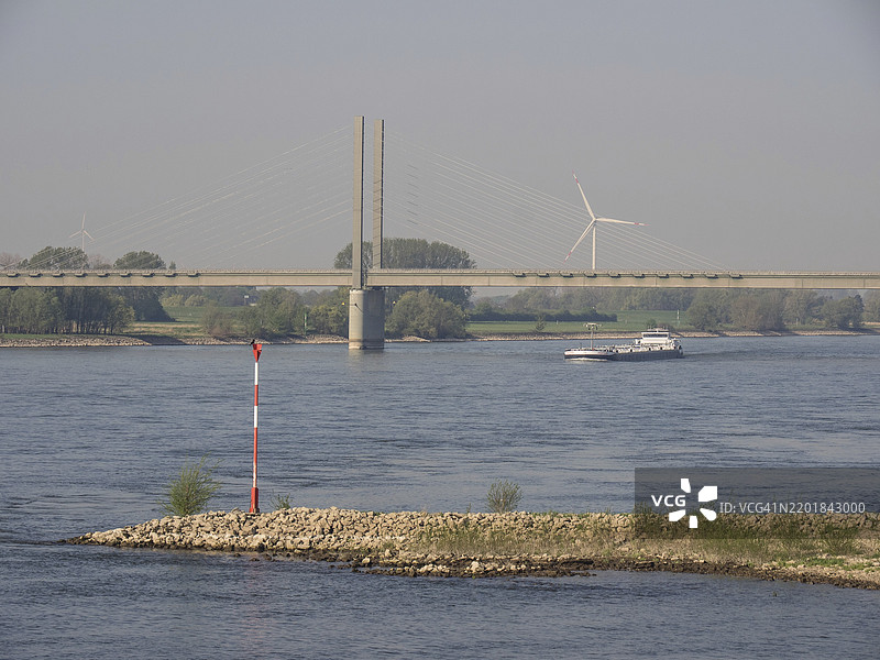 德国下莱茵地区卡尔卡尔的河上大桥，经过的船只和风力涡轮机图片素材