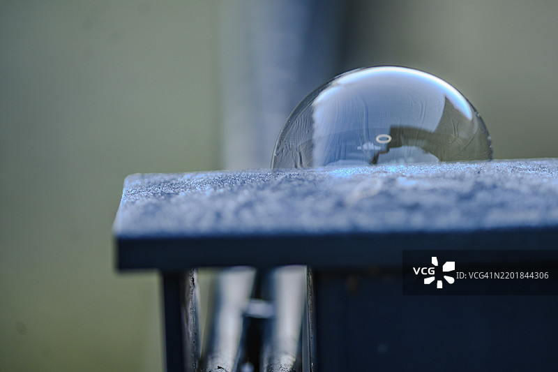 光滑表面上带有光线反射的肥皂泡特写图片素材