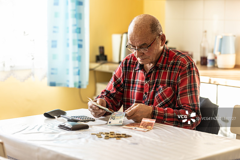 特写镜头：一位老年男性在数欧盟货币。图片素材