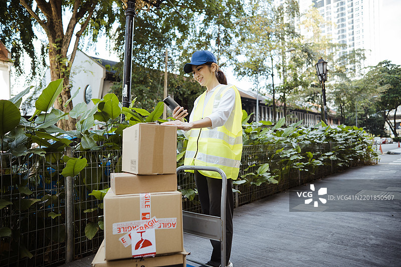 送货员在送货时用智能手机查看订单信息图片素材