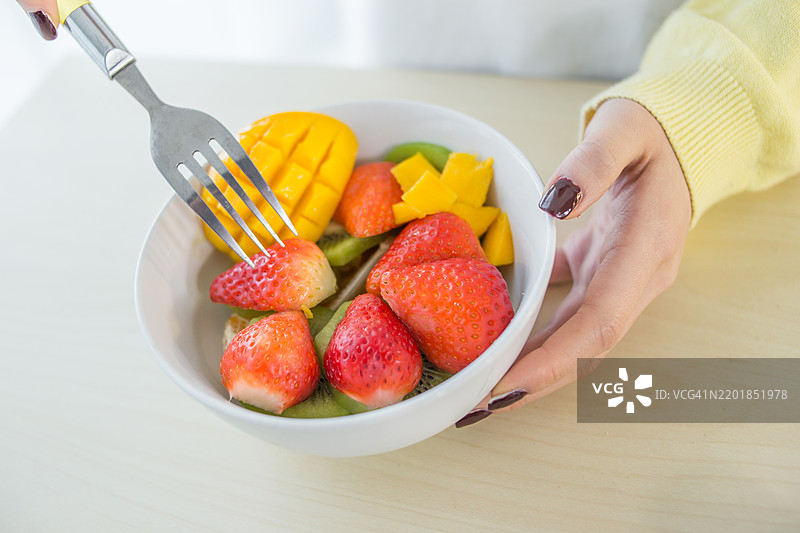 女人在吃热带水果沙拉图片素材