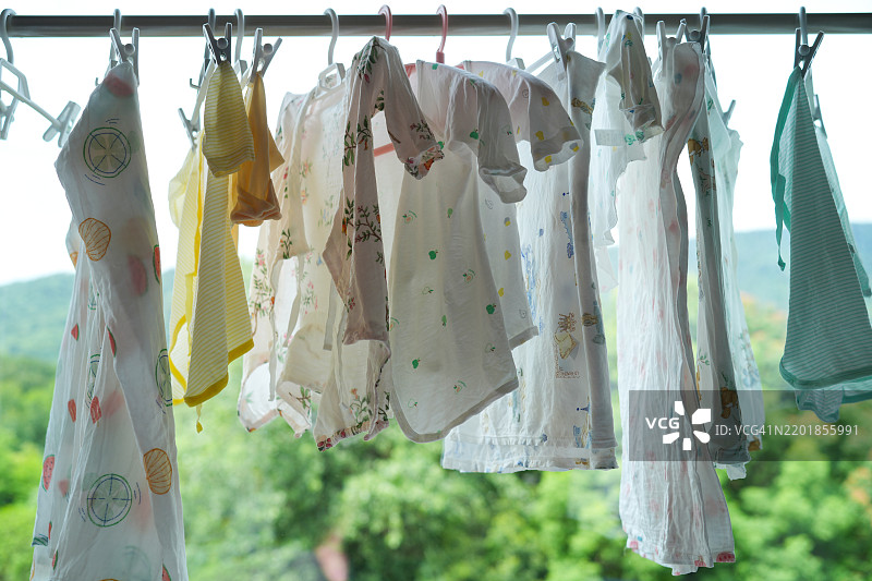 婴儿衣物在绿色森林背景下晾晒图片素材