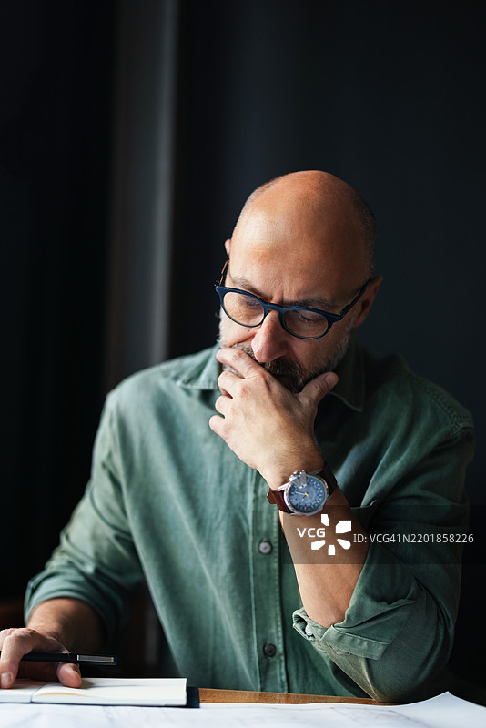 深思熟虑的商人在现代办公室环境中工作图片素材