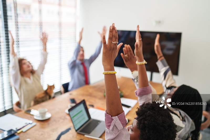 一群多样化的人在会议室里，放松着手臂。图片素材