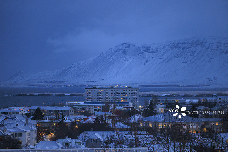 黎明时分的雪景雷克雅未克，背景是山脉图片素材