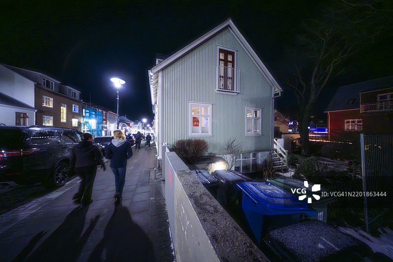 热闹的傍晚场景中的传统冰岛住宅图片素材