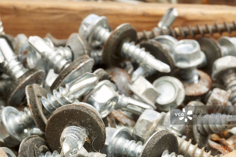 木箱中的屋顶螺丝和密封垫圈特写图片素材