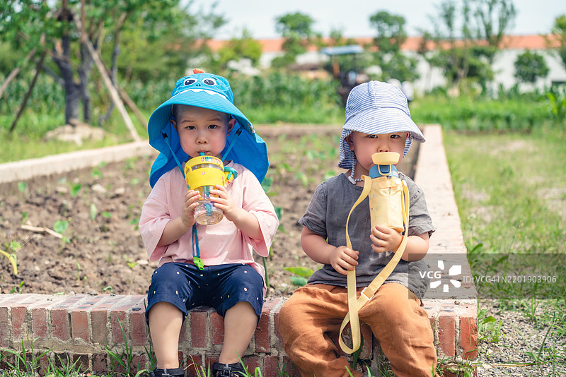 两个可爱的三岁男孩坐在一起喝水图片素材